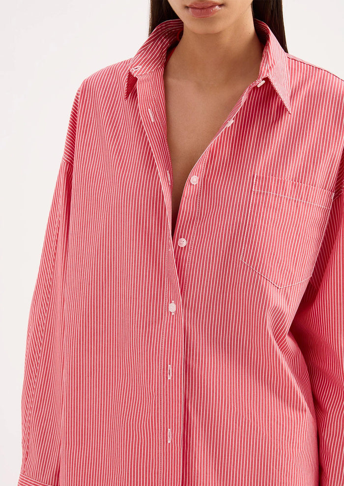 Red and white striped shirt worn by a person on a white background