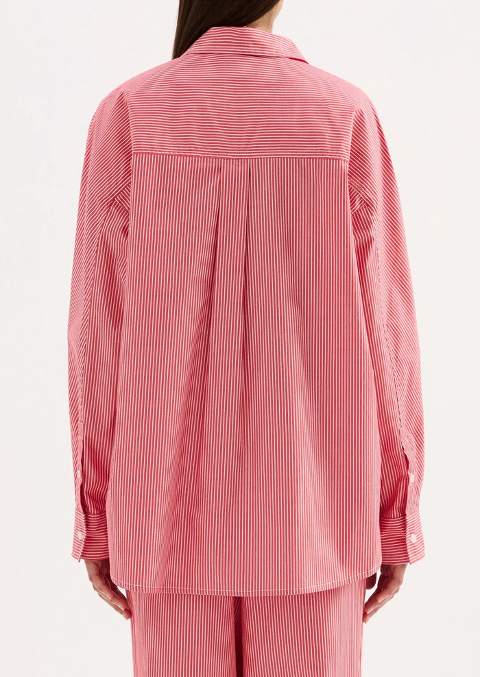 Pink striped shirt worn by a person on a white background