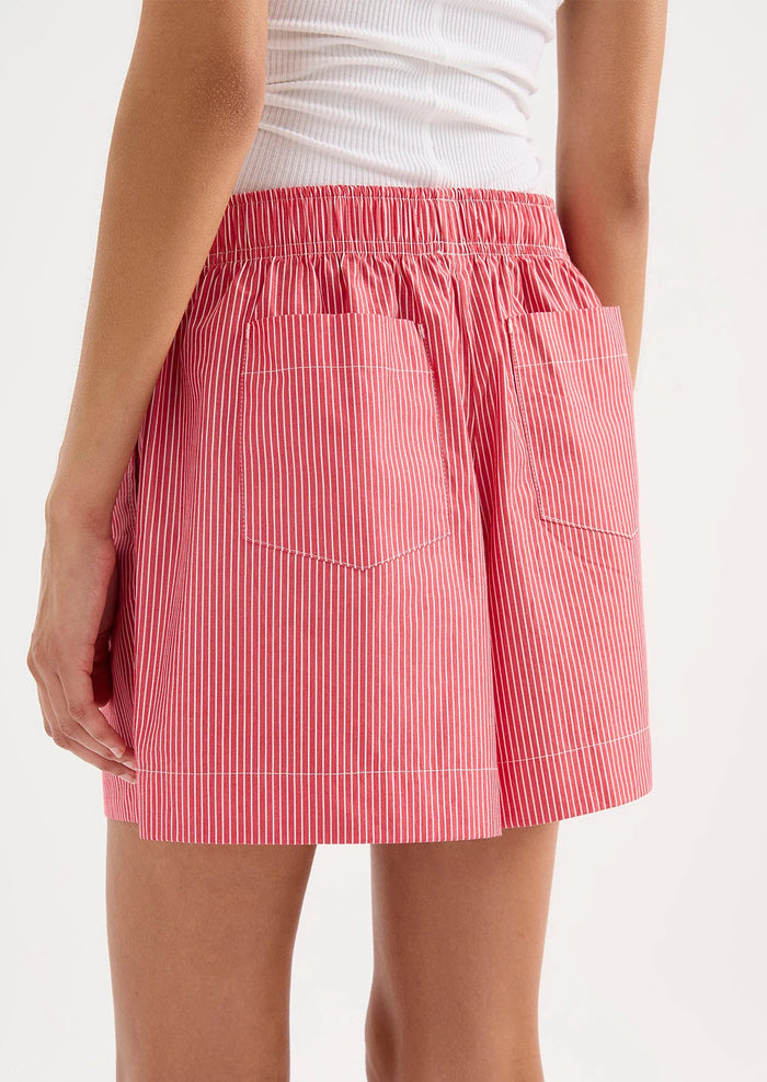 Red and white striped skirt worn by a person on a white background