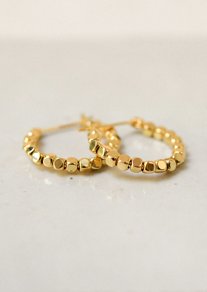 A pair of shiny gold hoop earrings.