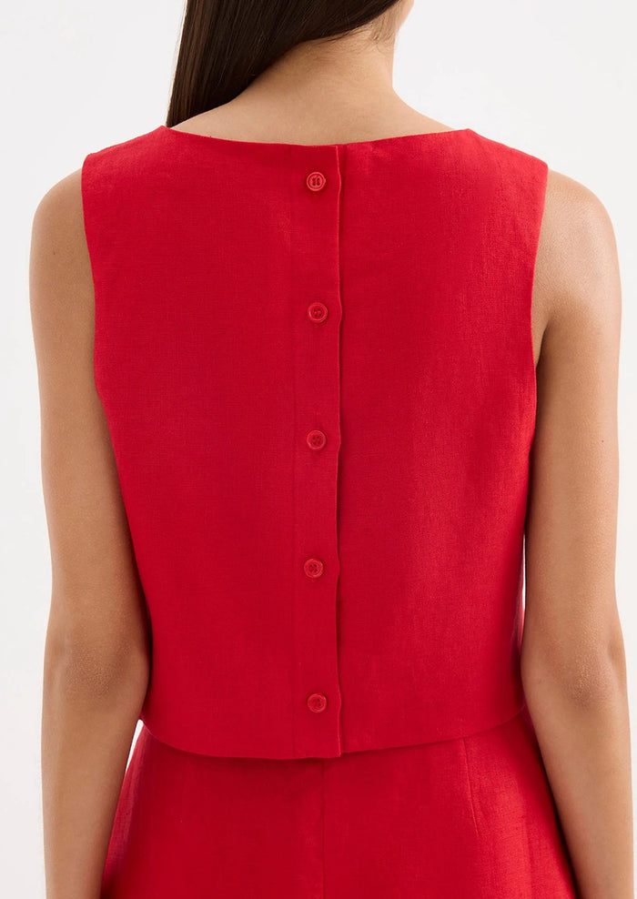Red sleeveless dress with button details on a white background