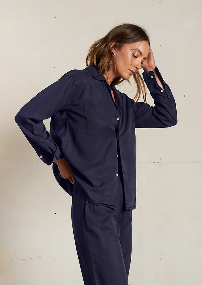 Woman wearing a navy blue outfit against a plain background
