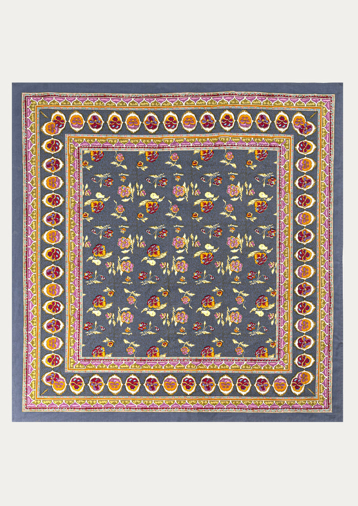 Decorative tablecloth with floral pattern and colorful border on a blue background