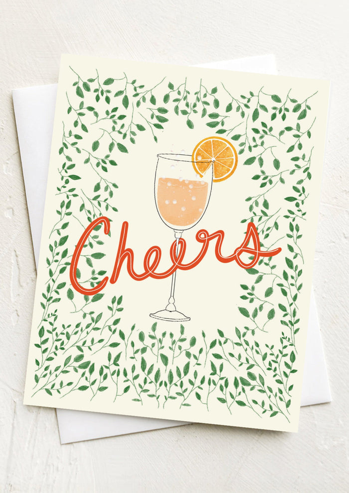 A greeting card with image of spritz cocktail glass, text reads "Cheers".